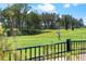 Personal playing golf at a community course with manicured green space and a black iron fence at 16112 Vetta Dr, Montverde, FL 34756