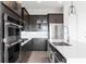 Close up of a modern kitchen featuring stainless steel appliances, dark wood cabinets, and a quartz countertop at 16112 Vetta Dr, Montverde, FL 34756