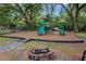Community playground with swings, slides, and picnic area beneath mature shade trees at 16112 Vetta Dr, Montverde, FL 34756