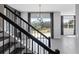 Interior view of a staircase with black railings looking out onto a large backyard through glass doors at 16112 Vetta Dr, Montverde, FL 34756