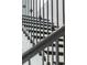 A close-up view of the staircase featuring dark iron railings with decorative caps and white risers at 16112 Vetta Dr, Montverde, FL 34756