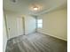 Bedroom features a gray carpet, white walls, double closet, and natural light from a window at 16380 Saint Kitts Circle, Clermont, FL 34714