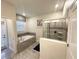 A relaxing bathroom showcasing a shower with glass door and a soaking tub beneath a window at 1656 Moon Valley Dr, Davenport, FL 33896