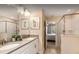 Bright bathroom with dual sinks, a shower, framed art and an open doorway to the bedroom at 1656 Moon Valley Dr, Davenport, FL 33896