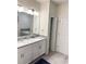 Bathroom featuring dual sinks, a large mirror, white cabinets, and tiled floors at 1656 Moon Valley Dr, Davenport, FL 33896