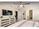 This stylish bedroom offers a dresser and flatscreen tv with an adjoining ensuite bathroom at 1656 Moon Valley Dr, Davenport, FL 33896