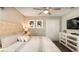 Relax in this comfortable bedroom with a decorative headboard, ceiling fan, and a flatscreen TV at 1656 Moon Valley Dr, Davenport, FL 33896