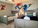 A whimsical bedroom boasts twin beds and a vibrant mural with everyone's favorite superhero at 1656 Moon Valley Dr, Davenport, FL 33896