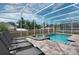 A screened-in pool and spa offer an inviting space to unwind, surrounded by a neatly maintained backyard at 1656 Moon Valley Dr, Davenport, FL 33896