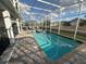 Screened-in pool area with a connected spa and lounge chairs, perfect for relaxation and enjoying sunny days at 1656 Moon Valley Dr, Davenport, FL 33896