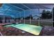 Screened pool area featuring a pristine pool, hot tub, and brick paver deck, perfect for outdoor relaxation and entertaining at 1656 Moon Valley Dr, Davenport, FL 33896