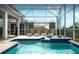 The refreshing pool and spa feature a screened-in enclosure and brick paver deck, perfect for sunny days at 1656 Moon Valley Dr, Davenport, FL 33896