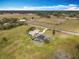 Aerial view of a home with an enclosed pool, a barn and open pastures surrounded by trees at 1680 Blackwelder Rd, De Leon Springs, FL 32130
