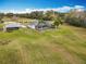Aerial view of pool, home, barn and lot featuring lush landscaping and a serene backyard at 1680 Blackwelder Rd, De Leon Springs, FL 32130