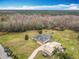 Aerial view of a home with a screened pool, a barn and a driveway near a beautiful wooded area at 1680 Blackwelder Rd, De Leon Springs, FL 32130