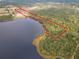 Aerial view of lot outlined in red, backing up to tranquil lake with mature trees at 1680 Blackwelder Rd, De Leon Springs, FL 32130
