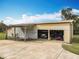 Barn exterior featuring open doors, concrete parking pad, and a covered area at 1680 Blackwelder Rd, De Leon Springs, FL 32130