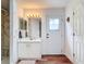 Bright bathroom features a walk-in shower, white vanity with mirror, and an exterior access door at 1680 Blackwelder Rd, De Leon Springs, FL 32130