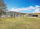 Traditional brick home featuring a manicured lawn, mature landscaping and a detached workshop at 1680 Blackwelder Rd, De Leon Springs, FL 32130