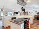 Open kitchen features an island cooktop, white cabinets, and seamless flow into the dining and living areas at 1680 Blackwelder Rd, De Leon Springs, FL 32130