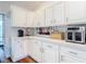 White kitchen with ample counter space, modern appliances, and views of the backyard at 1680 Blackwelder Rd, De Leon Springs, FL 32130