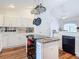 Modern kitchen features white cabinets, an island cooktop, and stainless steel appliances at 1680 Blackwelder Rd, De Leon Springs, FL 32130