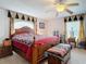 Well-lit main bedroom with a cozy four-poster bed, ceiling fan, and window with decorative valance at 1680 Blackwelder Rd, De Leon Springs, FL 32130