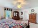 This spacious bedroom features ample wooden furniture, a patterned quilt, and bright natural light at 1680 Blackwelder Rd, De Leon Springs, FL 32130