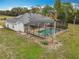 Aerial view of a screened-in pool and spa area with a solar panel house at 1680 Blackwelder Rd, De Leon Springs, FL 32130