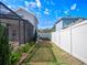 The backyard features a screened-in porch and garden bed enclosed by a white fence for privacy and relaxation at 1943 Kodsi Ct, Winter Garden, FL 34787