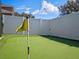 A backyard putting green with three holes, artificial turf, and a white vinyl fence surrounding the property at 1943 Kodsi Ct, Winter Garden, FL 34787