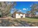 Side view of the home with an air conditioning unit and a spacious yard with trees at 203 North E Blvd, Davenport, FL 33837