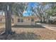 Quaint single-story home with mature trees creating a serene and inviting atmosphere at 203 North E Blvd, Davenport, FL 33837