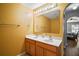 Bathroom featuring double sinks, a large mirror, yellow walls, and an arched entry to the bedroom at 2655 Sheila Dr, Apopka, FL 32712