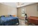 Simple bedroom with wood floors, single window, ceiling fan, and desk area for work or study at 2655 Sheila Dr, Apopka, FL 32712