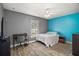 Bright bedroom featuring wood floors, ceiling fan, bright blue accent wall and large window at 2655 Sheila Dr, Apopka, FL 32712