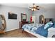 Main bedroom with wood floors, ceiling fan, television, and large dresser with mirror at 2655 Sheila Dr, Apopka, FL 32712
