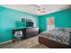 Vibrant bedroom with gray floors, a ceiling fan, work desk and a teal accent wall at 2655 Sheila Dr, Apopka, FL 32712