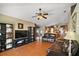 Open concept living room with leather sofas, ceiling fan, wood floors, and adjacent kitchen at 2655 Sheila Dr, Apopka, FL 32712