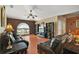 Spacious living room with large window, wood floors, sofas, ceiling fan, and open to the dining room at 2655 Sheila Dr, Apopka, FL 32712