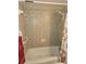 Full tub and shower with decorative tile and handrails at 333 Lake Howard Nw Dr # 201C, Winter Haven, FL 33880