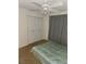 Cozy bedroom featuring a large bed, closet, ceiling fan, and neutral-colored carpet at 333 Lake Howard Nw Dr # 201C, Winter Haven, FL 33880