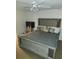 Bedroom with a ceiling fan, television, and large bed with an upholstered headboard at 333 Lake Howard Nw Dr # 201C, Winter Haven, FL 33880