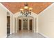 Hallway features decorative ceiling, stone tile flooring, and an elegant chandelier at 3412 Lilas Ct, Windermere, FL 34786