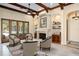 Elegant living room with a fireplace, wooden beams, and a view of the pool area at 3412 Lilas Ct, Windermere, FL 34786