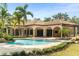 Inviting backyard pool with a luxurious tile patio, lush landscaping, and an elegant, arched covered lanai at 3412 Lilas Ct, Windermere, FL 34786