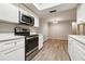 Modern kitchen with stainless steel appliances, white cabinets, and an adjacent dining area at 353 E Orange St, Altamonte Springs, FL 32701
