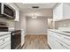 Updated kitchen with stainless steel appliances and white cabinetry overlooking dining area at 353 E Orange St, Altamonte Springs, FL 32701