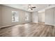 Spacious living room featuring wood-look floors, ceiling fan, and natural light from two windows at 353 E Orange St, Altamonte Springs, FL 32701