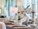 Beautifully decorated dining table with elegant place settings and floral centerpiece in a bright, modern dining space at 3540 Fort Mellon Ln, Sanford, FL 32773